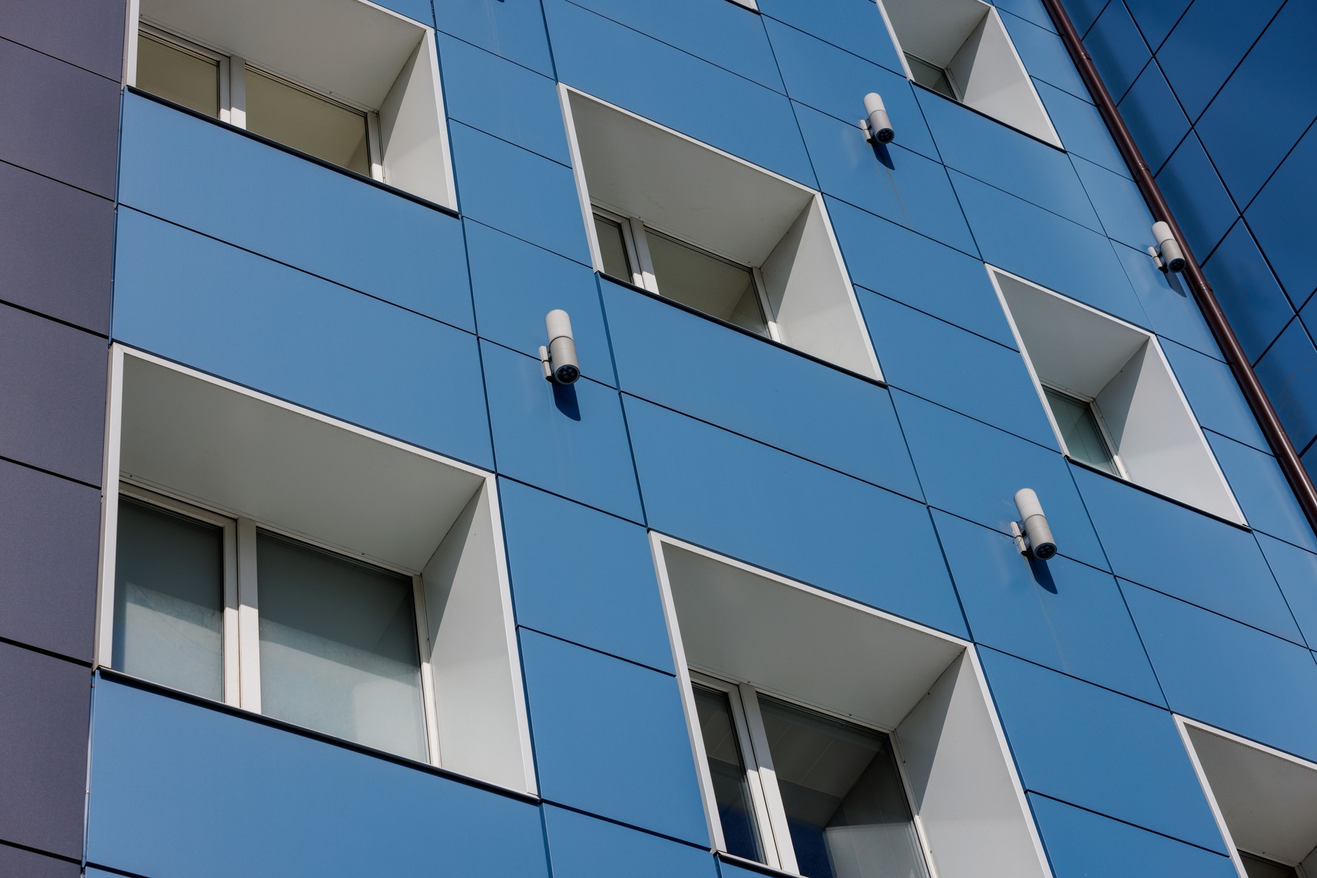 generic blue office building wall with windows and composite aliminium panels, diagonal upward view