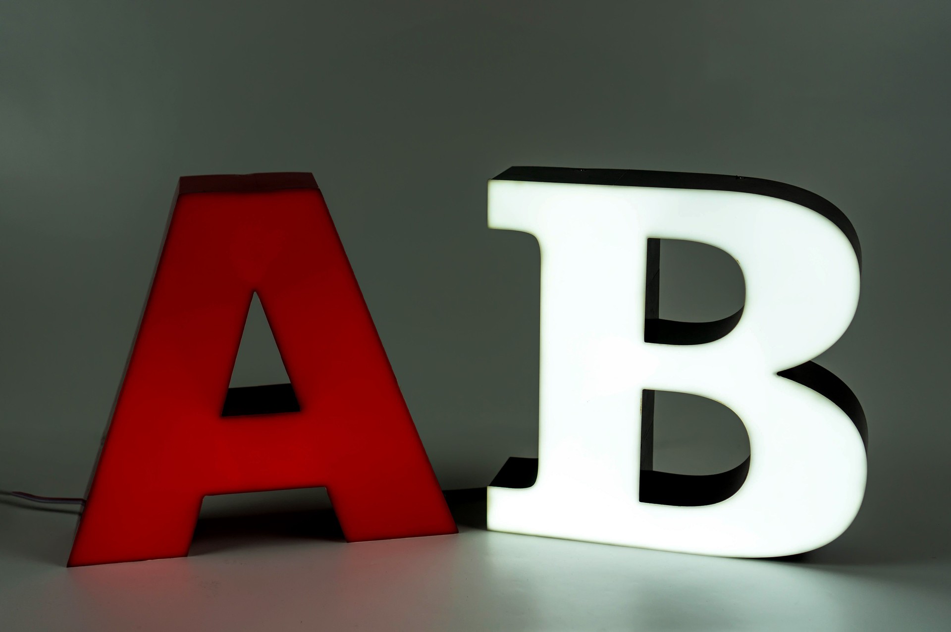 The light volumetric letters A and B are part of an advertising sign. Aluminum sidewall. Red and white.