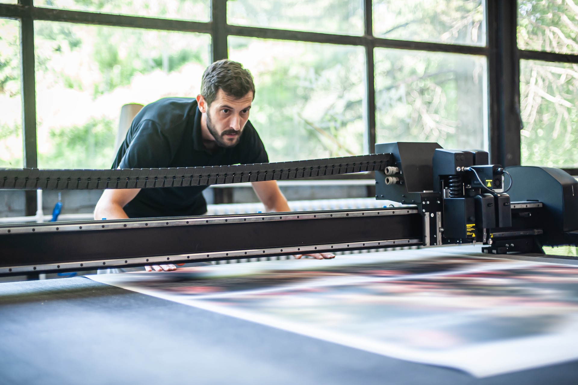 Professional worker printmaker technician operator works in modern printing plant